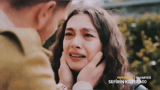 a man is touching a woman 's face with the words sefirin kizi written on the bottom