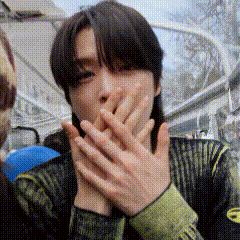 a man is covering his mouth with his hands .