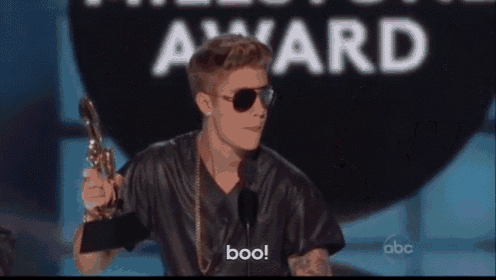 justin bieber is holding a trophy and says boo