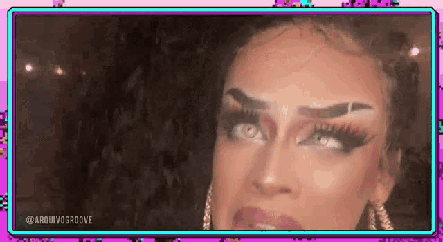 a close up of a drag queen 's face with a purple background .