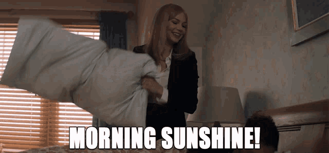 a woman holding a pillow with the words morning sunshine written above her