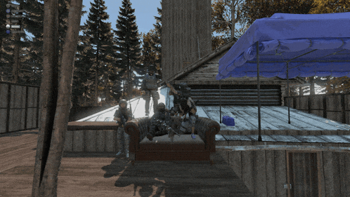 a group of soldiers sitting on a couch in front of a blue tent