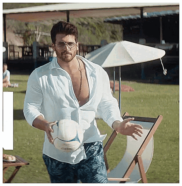 a man in a white shirt is holding a ball