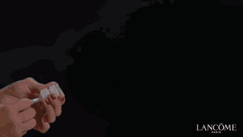 a bottle of lancome perfume is being sprayed