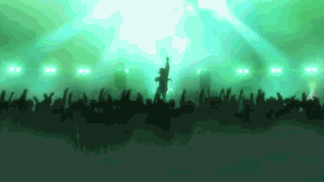 a silhouette of a man standing on a stage with a crowd behind him
