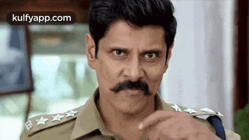 a police officer with a mustache is making a funny face .
