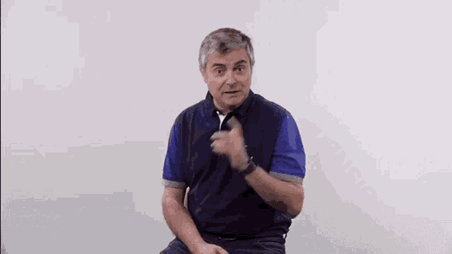 a man in a blue shirt is pointing at the camera with the words " geateu tension " above him