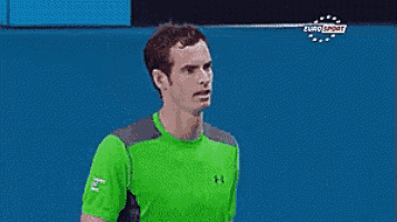 a man in a green under armour shirt is standing next to a man in a hat .