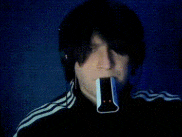 a man in a black and white adidas jacket is smoking a cigarette
