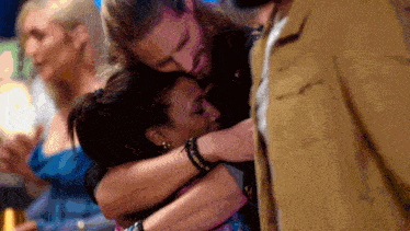 a man is hugging a woman with a bracelet on her wrist that says " i love you "
