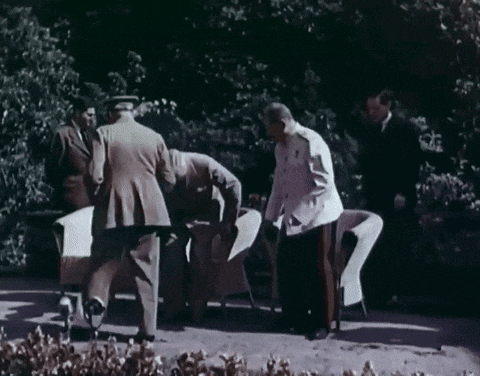a group of men are standing around a table and one of them is looking down