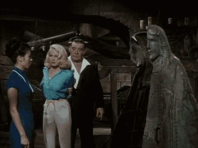 a man and two women are standing in front of a statue of jesus