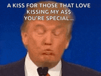 a man in a suit and tie is blowing a kiss for those that love kissing his ass .