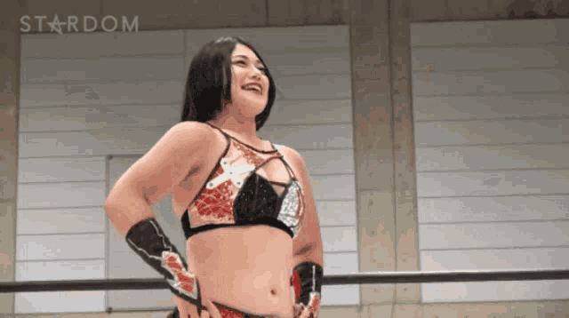 a woman stands in a wrestling ring with the word stardom behind her