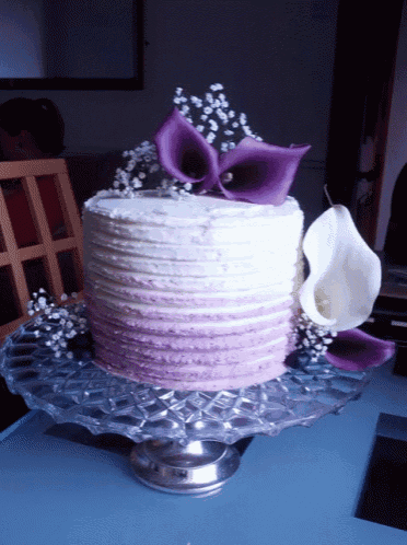 a purple and white cake with purple flowers and baby 's breath