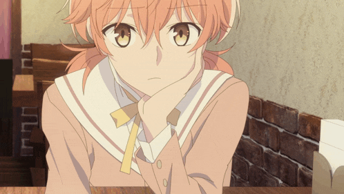 a girl with orange hair is sitting at a table with her head resting on her hand