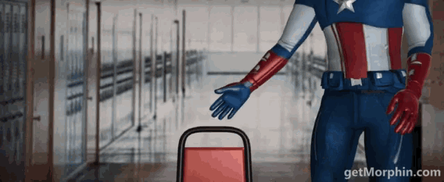 a man in a superhero costume is standing in a hallway with getmorphin.com in the corner