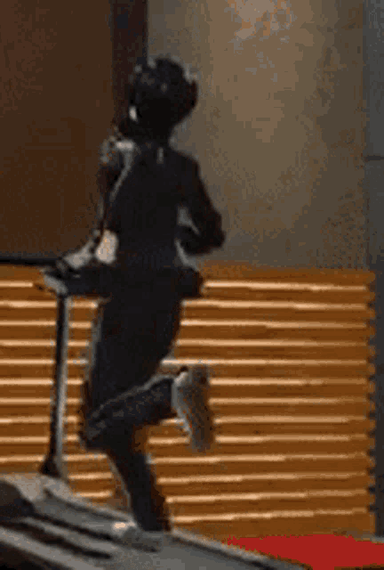 a person is running on a treadmill in a room with stairs in the background .
