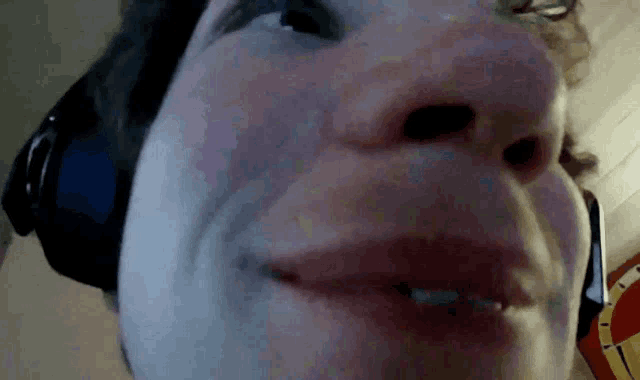a close up of a person 's face with a headphone on
