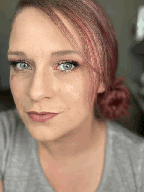 a close up of a woman 's face with a gray shirt on