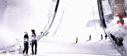 people skiing down a snow covered slope with a sign that says lewanaria in the background