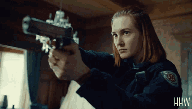 a woman holding a gun with the word hw on the bottom left