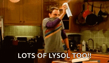 a man is spraying a can of lysol on a counter in a kitchen .