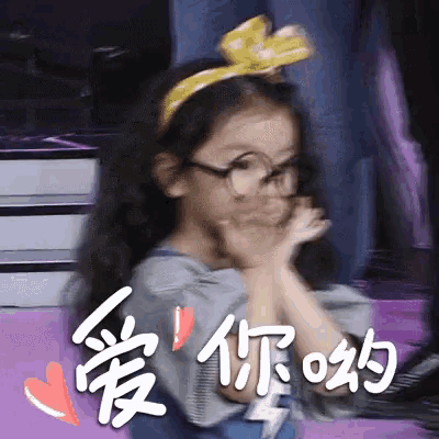 a little girl wearing glasses and a yellow headband with chinese writing