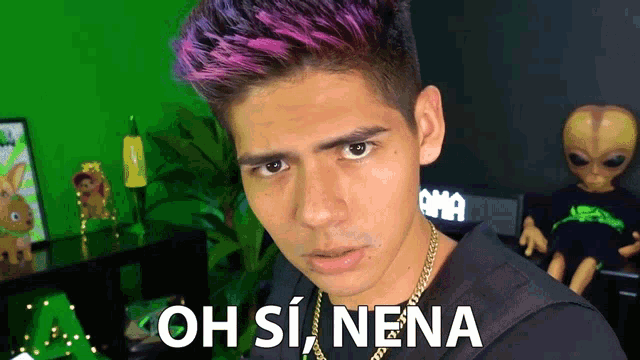 a man with purple hair is standing in front of a green background with the words oh si nena written on it