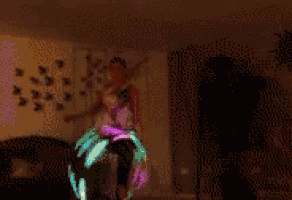 a group of people are dancing in a dark room with a glowing object in the background .