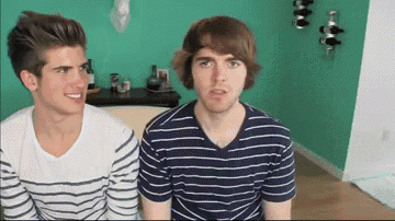 two men are sitting next to each other in a room