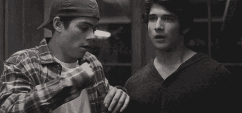a couple of men are shaking hands in a black and white photo .