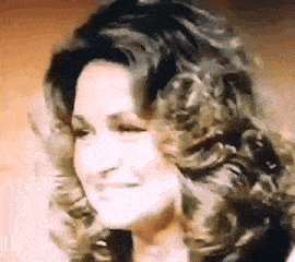 a close up of a woman 's face with curly hair .