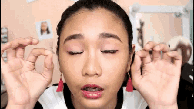a woman with her eyes closed and her hands on her face .