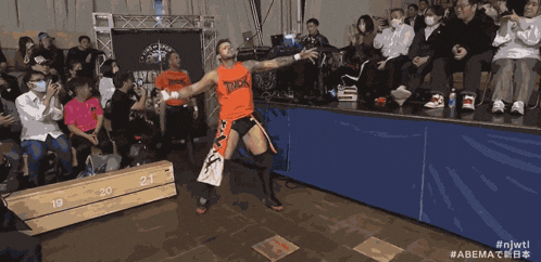 two men wearing orange shirts that say tmdk on them