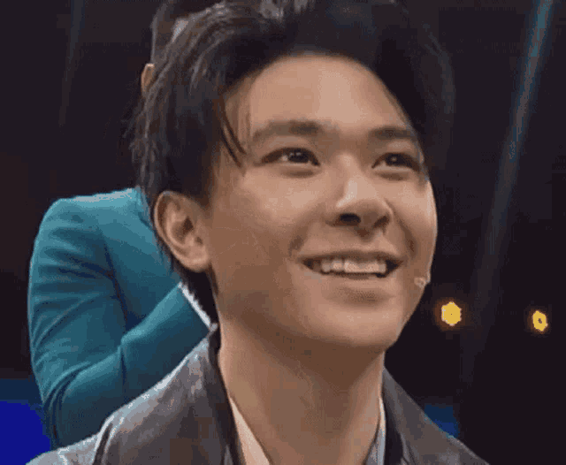 a close up of a young man 's face with a microphone in his mouth .