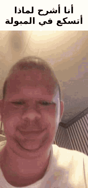 a man is making a funny face while wearing a white shirt with arabic writing on it .
