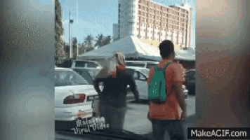 a man and a woman are standing next to each other in front of a white car .
