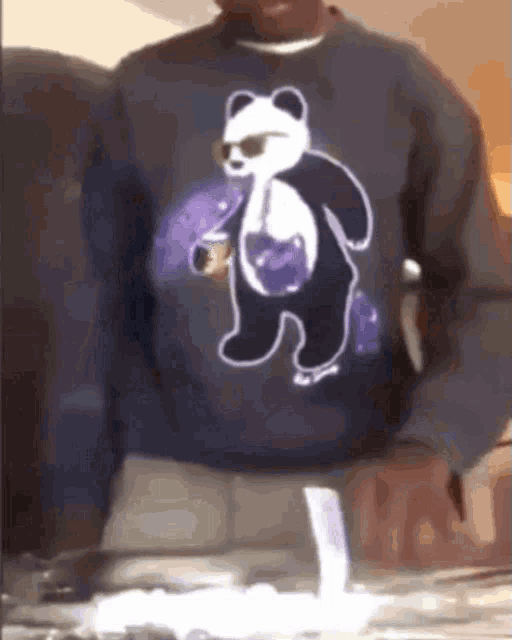 a man is wearing a sweater with a panda bear on it .