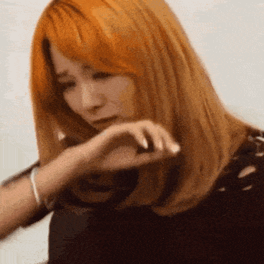 a woman with red hair is crying and covering her face with her hands .