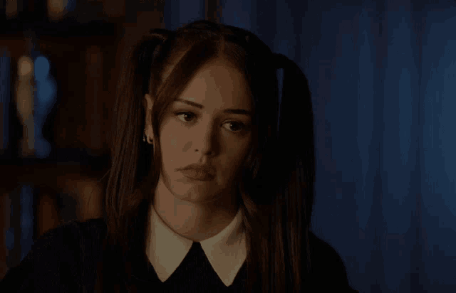 a girl with pigtails is wearing a black dress and white collar