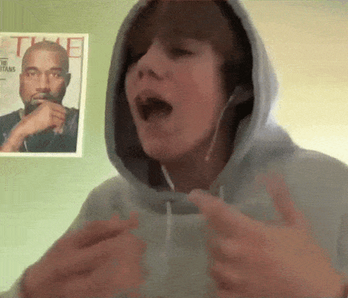 a young man wearing headphones is singing in front of a time magazine poster