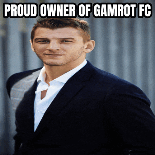 a man in a suit and white shirt with the words proud owner of gamrot fc above him