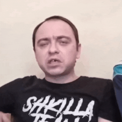 a man wearing a shirt that says ' sakilla team ' on it is making a funny face
