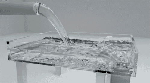 water is being poured into a clear glass container
