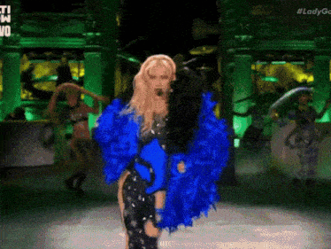 a woman in a blue and black outfit is dancing on a stage with #ladygo written on the bottom right