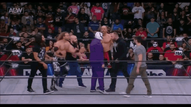 a group of wrestlers are standing in a ring with the aew logo visible