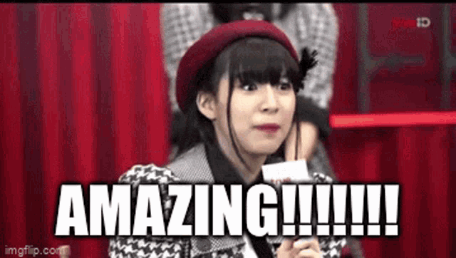a girl in a red hat is holding a piece of paper that says amazing