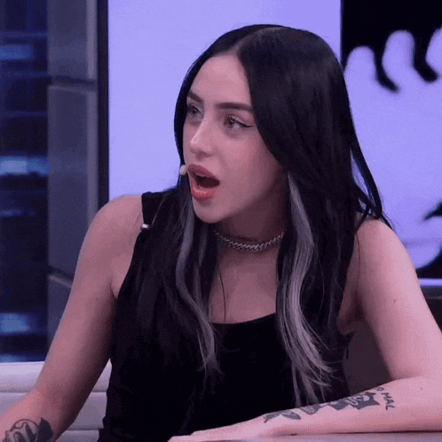 a woman with black hair has a tattoo on her arm that says ' hal '
