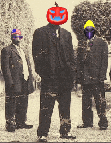 a man with a pumpkin on his head stands between two other men in suits